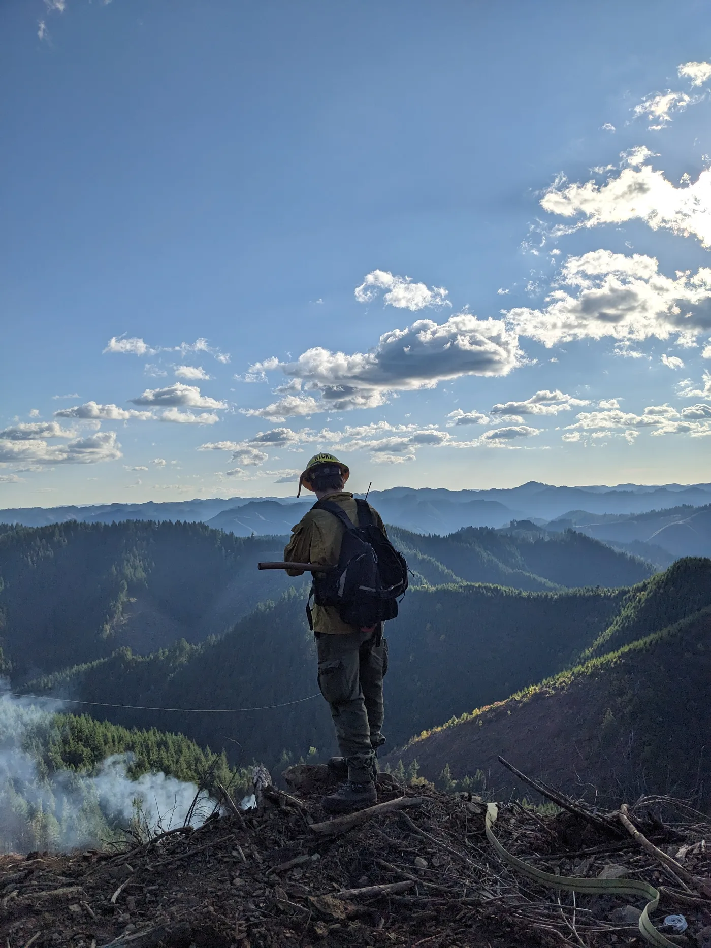 Taylor on a ridge during fire-season work, looking out over the mountains
